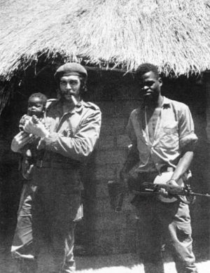 Che in Congo next to an Afro-Cuban soldier and holding a Congelese baby, 1965.